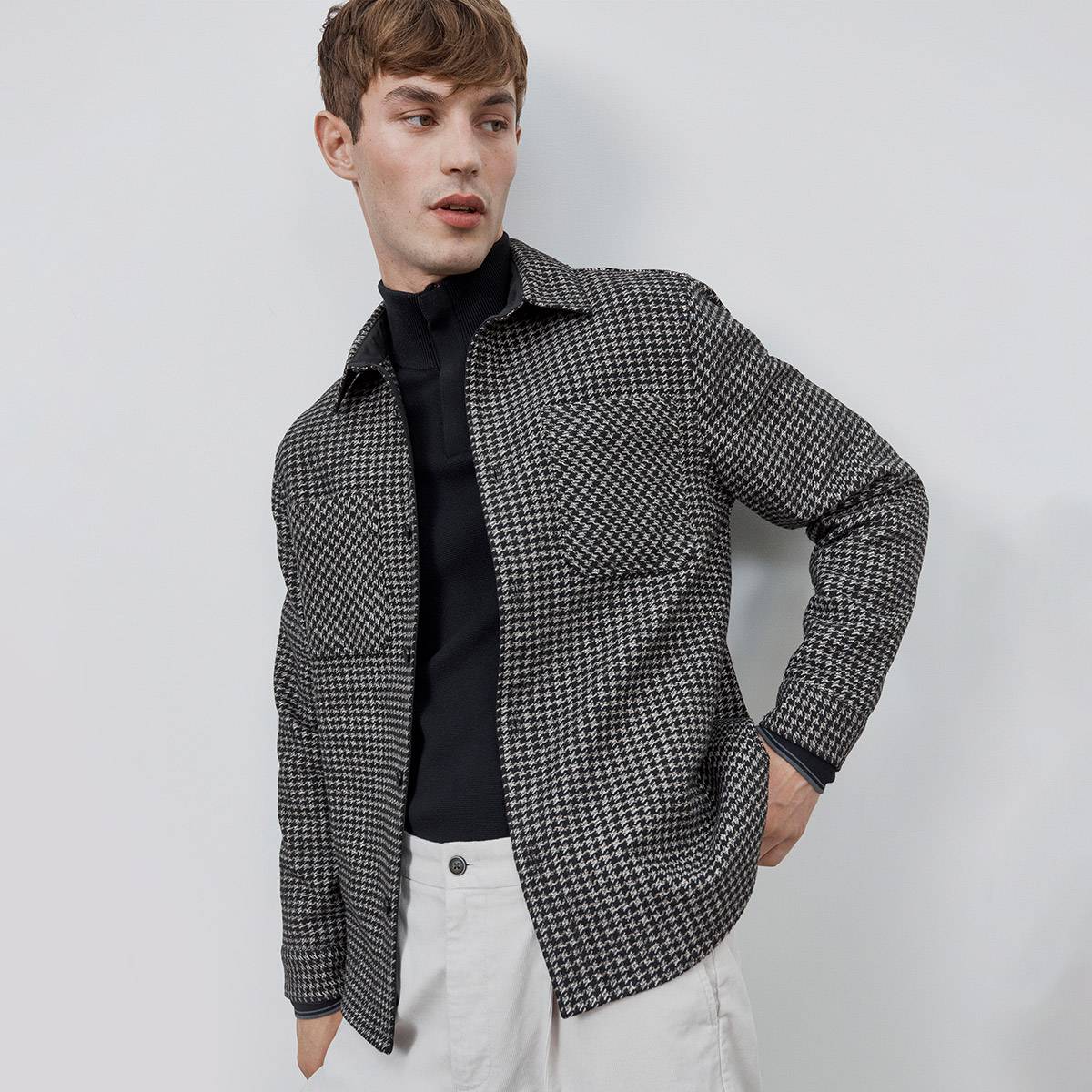 Man wearing checked jacket, black top and white trousers. Shop men’s Autograph 